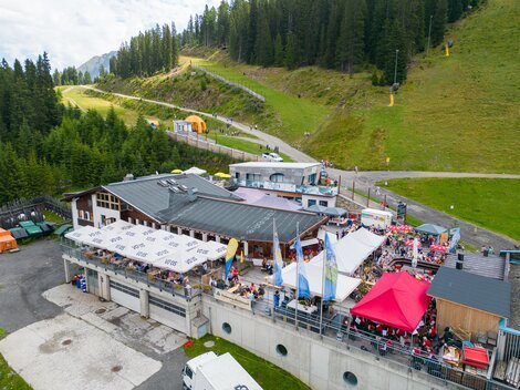 Ein beliebtes Bergrestaurant mit einer großen Terrasse und vielen Gästen. Umgeben von Wäldern und Bergen bietet es einen schönen Ausblick. | © Christian Barz