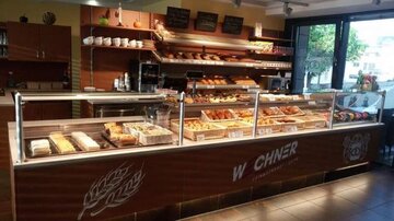 Eine attraktive Bäckerei mit einer Vielzahl von frischen Backwaren und einer einladenden Theke. Helle und moderne Einrichtung mit viel natürlichem Licht.
