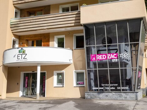Ein modernes Geschäftshaus mit der Aufschrift "ETZ" und "RED ZAC". Gut sichtbare Fenster und ein ansprechendes Design.
